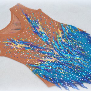 May include: A brown leotard with a blue and yellow flame design and rhinestones.