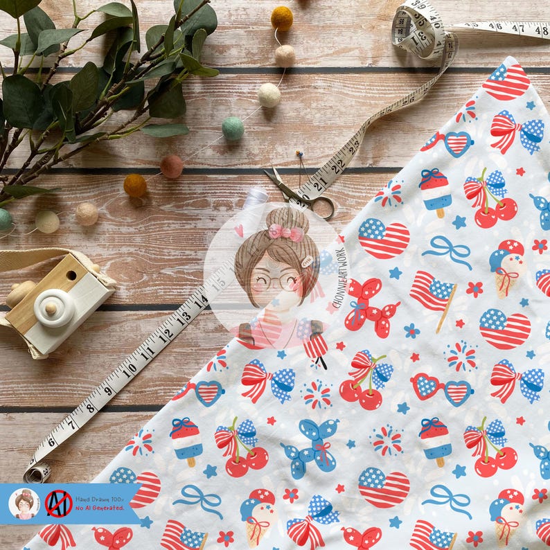 May include: White fabric with a red, white, and blue patriotic print featuring cherries, fireworks, stars, bows, and ice cream cones. The fabric is folded in half and a measuring tape is visible in the background.