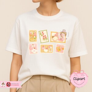 May include: White t-shirt featuring a colorful stamp design. The stamps depict various illustrations, including floral arrangements, a woman with glasses, and decorative objects. The shirt has short sleeves and a crew neck.