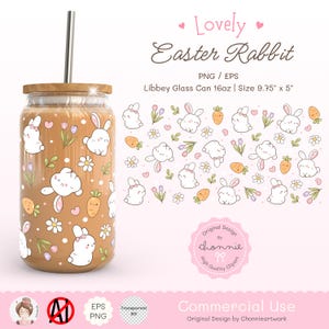 Könnte beinhalten: Ein klares Glas mit Bambusdeckel und Metallstrohhalm. Es ist mit einem sich wiederholenden Muster aus weißen Hasen, Karotten und Blumen verziert. Der Text "Lovely Easter Rabbit" steht oben. Größe: ca. 24.77 cm x 12.7 cm.