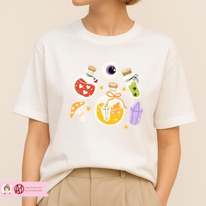 May include: Cream-colored t-shirt featuring a whimsical illustration of potion bottles, a purple eye, a mushroom, and a crystal. The bottles contain various colorful liquids and decorative elements. The design includes small stars.