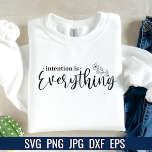 K&ouml;nnte beinhalten: Ein wei&szlig;es Sweatshirt mit dem Schriftzug "intention is Everything" in schwarzer Schrift. Ein floraler Zweig befindet sich neben dem Wort "Everything". Am unteren Bildrand stehen die Dateitypen: SVG PNG JPG DXF EPS.