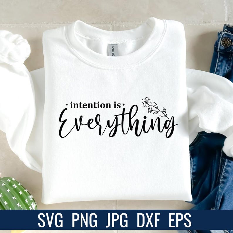 K&ouml;nnte beinhalten: Ein wei&szlig;es Sweatshirt mit dem Schriftzug "intention is Everything" in schwarzer Schrift. Ein floraler Zweig befindet sich neben dem Wort "Everything". Am unteren Bildrand stehen die Dateitypen: SVG PNG JPG DXF EPS.