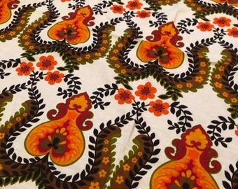 May include: A white fabric with a repeating pattern of orange, brown, and green floral designs. The pattern features stylized leaves and flowers.