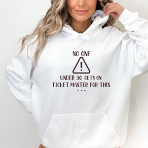 May include: White hoodie with a brown graphic that says "No one under 30 gets on Ticketmaster for this..."