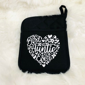 May include: Black oven mitt with a white heart design that says "Best Auntie Ever" surrounded by small white flowers and hearts.