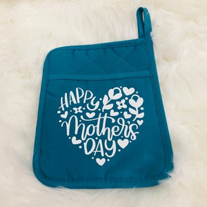 May include: Teal blue quilted oven mitt with a white heart design that says "Happy Mother's Day" with floral accents.