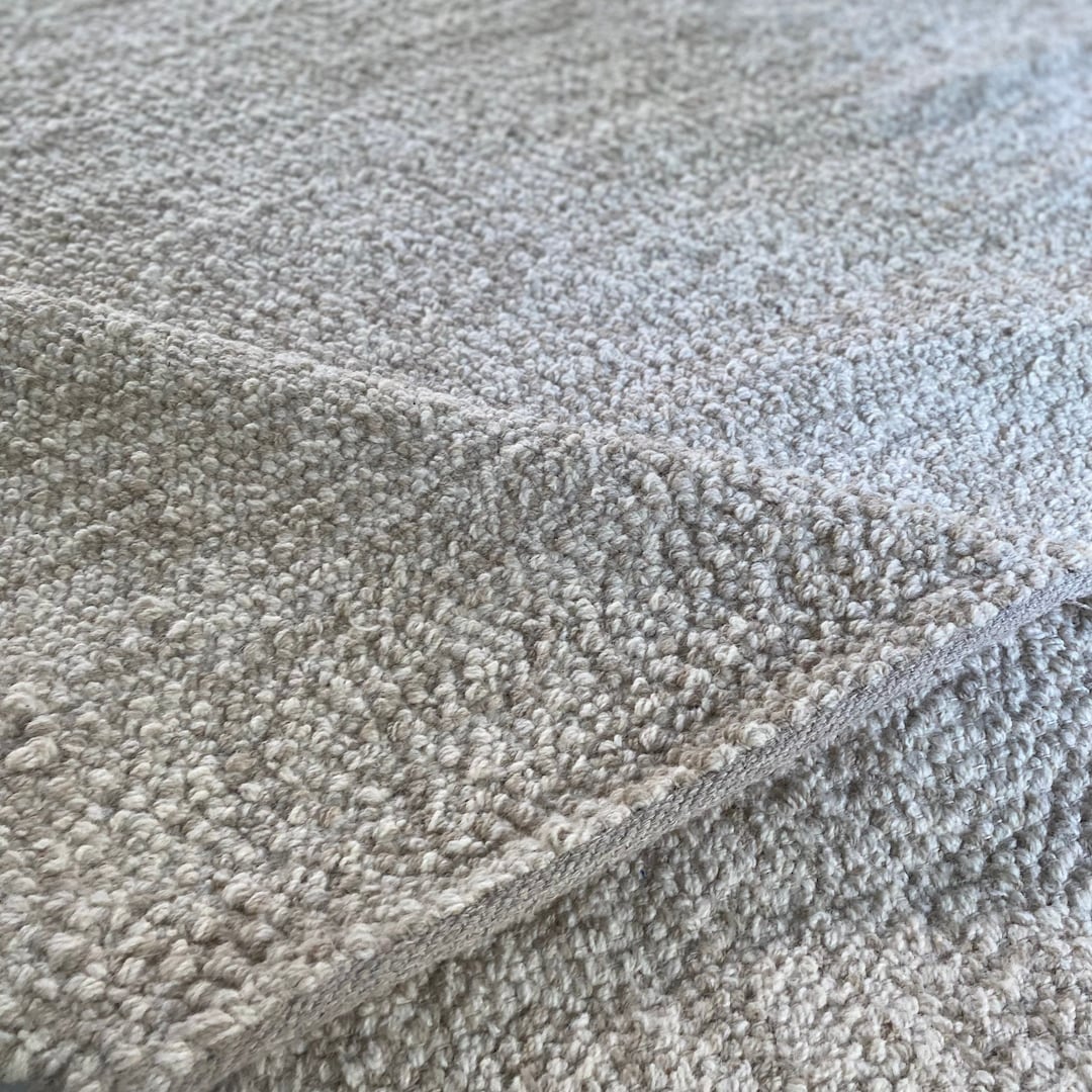 手編みのベージュ＆クリーム色のロープスタイルのフェルトウールラグ