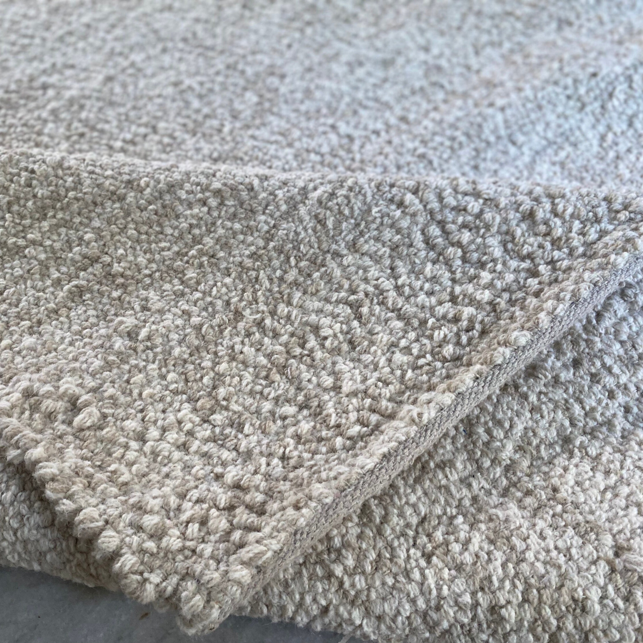 手編みのベージュ＆クリーム色のロープスタイルのフェルトウールラグ