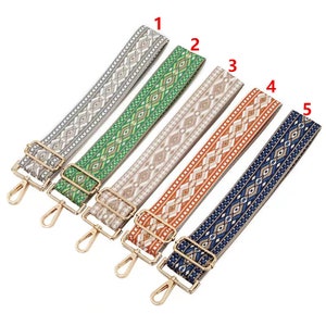 Può includere: Cinque cinturini intrecciati con diversi motivi e fibbie in metallo dorato. I cinturini sono di vari colori, tra cui grigio, verde, beige, arancione e blu.