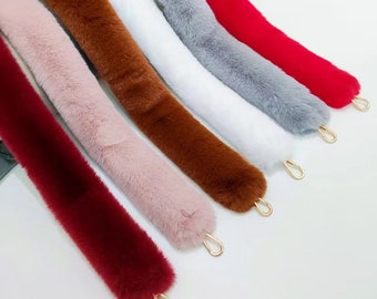 May include: Six faux fur straps with gold metal clasps. The straps are in the colors red, brown, pink, white, gray, and a darker red.