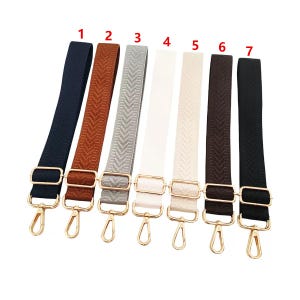 Può includere: Sette tracolle regolabili per borse in vari colori: blu navy, marrone, grigio, bianco, crema, marrone scuro e nero. Ogni tracolla ha un fermaglio e una fibbia in metallo dorato per il fissaggio alla borsa. Motivo a spina di pesce intrecciato.