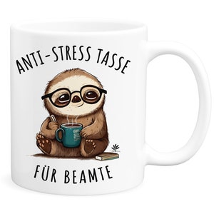 Könnte beinhalten: Weiße Keramiktasse mit einem braunen Faultier, das eine Brille trägt und eine blaue Tasse mit einem dampfenden Getränk hält. Die Tasse hat den Text "Anti-Stress Tasse für Beamte" aufgedruckt.