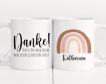 May include: Two white ceramic mugs with a rainbow design and the text "Danke! Dass du mir beim wachsen geholfen hast" and "Katharina".