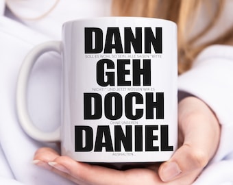 May include: White ceramic mug with black text that reads "Dann soll es wohl so sein. Alle sagen 'Bitte geh nicht!' und jetzt müssen wir es doch ohne unseren Daniel aushalten..."
