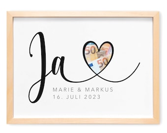 May include: A printable "Ja" wedding money box with a heart-shaped opening for money. The text "Marie & Markus 16. Juli 2023" is below the heart. The text "Zum selber ausschneiden" is below the image.