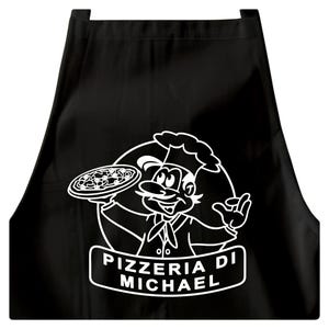 Könnte beinhalten: Schwarze Schürze mit einem weißen Cartoon-Koch, der eine Pizza hält. Der Koch trägt eine hohe Mütze und eine Krawatte. Der Text "PIZZERIA DI MICHAEL" wird in einem weißen rechteckigen Banner unter der Kochillustration angezeigt.