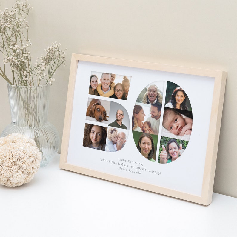 May include: A framed photo collage in a light wood frame with a white mount. The collage is made up of photos of different people and a dog. The photos are arranged in the shape of the number 50. The text "Liebe Katharina, alles Liebe & Gute zum 50. Geburtstag! Deine Freunde" is printed below the collage.