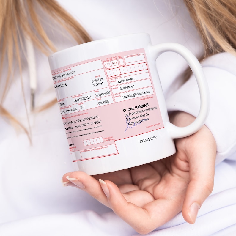 K&ouml;nnte beinhalten: Wei&szlig;e Keramiktasse mit einem rosafarbenen Design im Stil eines Rezepts. Die Tasse zeigt den Text "Deine beste Freundin Martina" und "Dr. med. HANNAH Die Arztin deines Vertrauens Gule-Laune Allee 24 2291 Morganstadt".