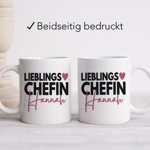 May include: Two white ceramic mugs with black text that reads "Lieblings Chefin Hannah" and a pink heart. The mugs are printed on both sides.