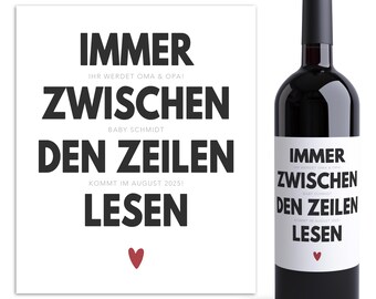 May include: A bottle of red wine with a white label featuring black text that reads "IMMER ZWISCHEN DEN ZEILEN LESEN" and a small red heart. A matching print with the same text is to the left.