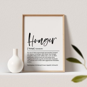 May include: A framed print with the word "Hunger" in a handwritten style. The print includes a definition in German, a white vase, and a sprig of greenery.