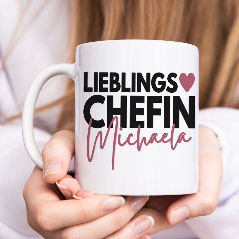 May include: White ceramic mug with a black and pink design. The mug says "Lieblings Chefin Michaela" with a pink heart.