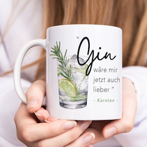 Könnte beinhalten: Weißer Keramikbecher mit einer Illustration eines Gin-Cocktails mit Eis, Limette und Rosmarin. Der Becher hat das Wort "Gin" in Schreibschrift, sowie deutschen Text und den Namen "Karsten".