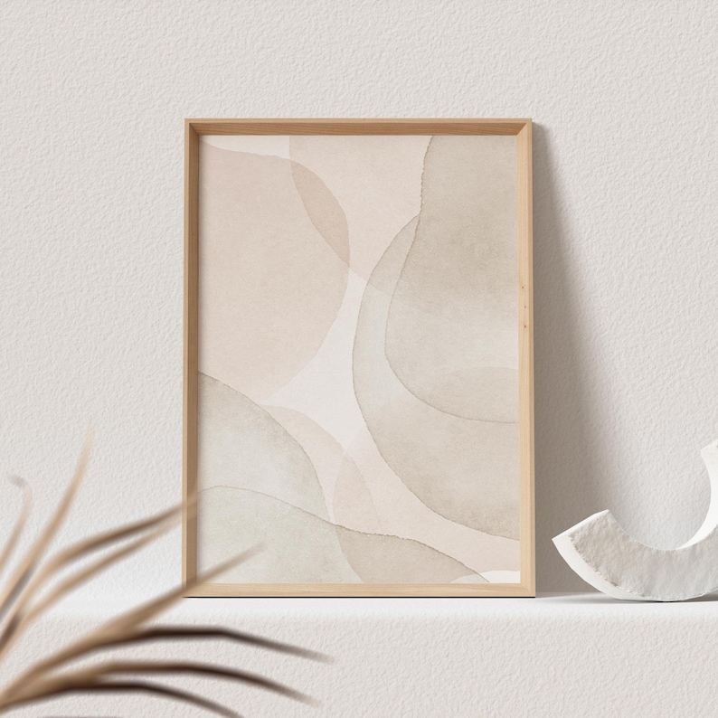 May include: A framed abstract print with a beige and light green watercolor design. The print is in a light wood frame.