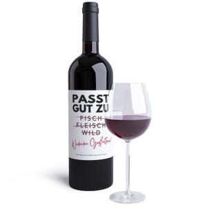 May include: A bottle of red wine with a white label that says "PASST GUT ZU" with lines through "FISCH", "FLEISCH", and "WILD". The label also says "Weekenden Gr&uuml;&szlig;e" and "BABY MELLER KOMMT IM AUGUST 2020". A glass of red wine is in front of the bottle.