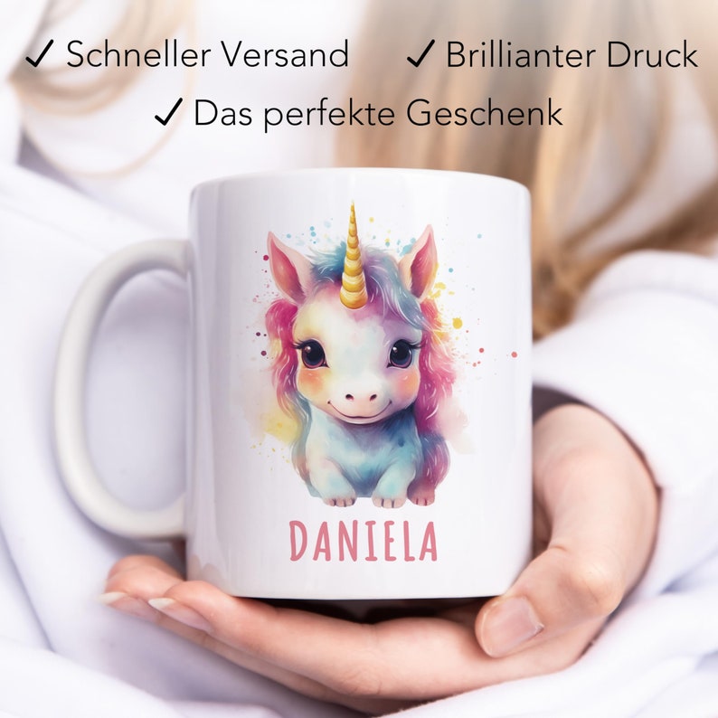 May include: White ceramic mug featuring a colourful unicorn illustration and the name "DANIELA" printed on the bottom.