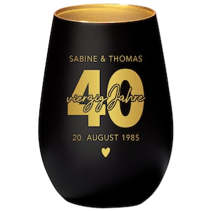 Könnte beinhalten: Ein schwarzes, stieloses Weinglas mit goldenem Rand und goldener Schrift. Der Text lautet "SABINE & THOMAS", "40 vierzig Jahre" und "20. AUGUST 1985" mit einem goldenen Herz darunter. Ein Geschenk zum Hochzeitstag.