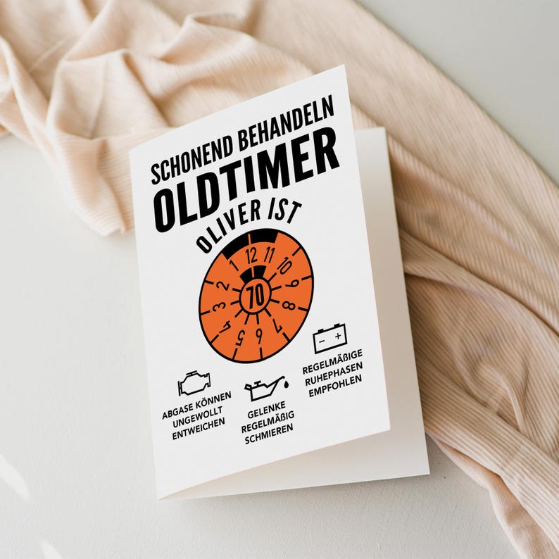 May include: A white card with black text that reads "Schonend Behandeln Oldtimer Oliver ist" with an orange speedometer graphic and text that reads "Abgase konnen ungewollt entweichen, Gelenke regelmabig schmieren, Regelmabige Ruhephasen empfohlen".