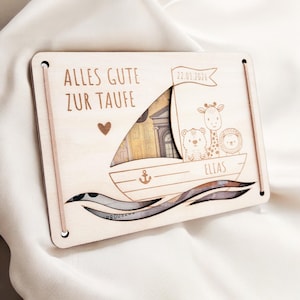 K&ouml;nnte beinhalten: Holzk&auml;rtchen mit dem Text "Alles Gute zur Taufe" und dem Datum "22.03.2026". Die Karte zeigt einen Ausschnitt eines Bootes mit Tieren darauf, darunter eine Giraffe, ein B&auml;r und ein L&ouml;we. Der Name "Elias" steht auf dem Boot.
