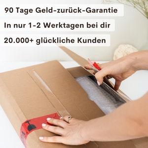 May include: A brown cardboard box with a red tape seal. The box is being opened by a hand. The text on the box reads "90 Tage Geld-zur&uuml;ck-Garantie", "In nur 1-2 Werktagen bei dir", and "20.000+ gl&uuml;ckliche Kunden".