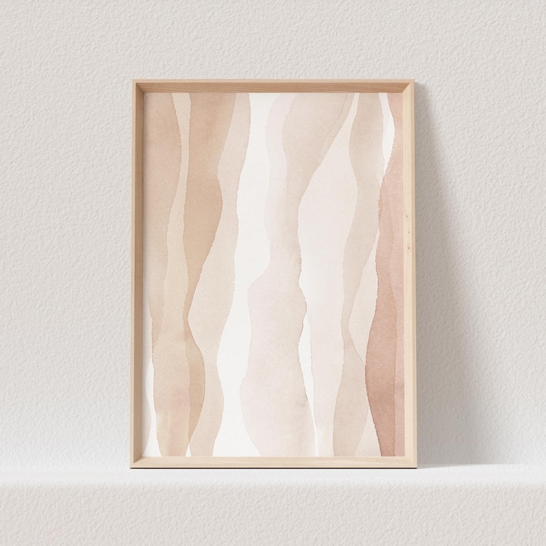 May include: Abstract art print featuring a watercolour design of wavy lines in shades of beige and brown. The print is framed in a light wood frame.