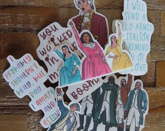 May include: A collection of colorful stickers featuring illustrations of characters and quotes from a musical. The stickers include images of people in period clothing and phrases like "Boom!" and "I will send a fully-armed battalion."