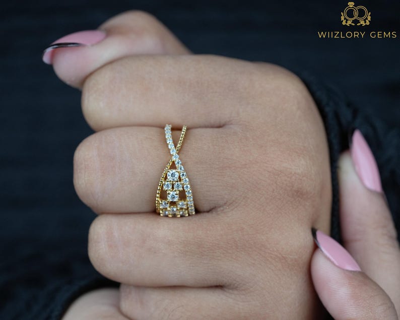 May include: A gold-toned ring with a unique design, featuring a series of small, sparkling stones. The ring has an open, interwoven structure, with the brand name "WIIZLORY GEMS" in the upper right corner.