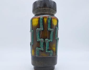 May include: A ceramic vase with a dark brown top and base, featuring a yellow and brown body with a geometric teal design. The vase has a cylindrical shape and a textured surface, suitable for home decor.
