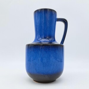 Könnte beinhalten: Eine blaue Keramikvase mit Henkel. Die Vase hat eine dunkelblaue Glasur mit einem schwarzen Rand.
