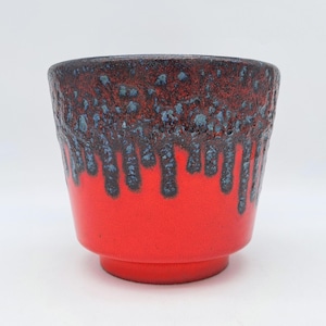 Peut inclure: Un pot en céramique rouge avec un glaçage noir et bleu. Le glaçage a un effet de goutte à goutte, créant un look unique et moderne.