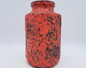 Op de afbeelding: Een cilindervormige rode keramische vaas met een textuuroppervlak en zwarte bloempatronen. De vaas heeft een brede basis en een smallere hals. Het ontwerp is een mix van moderne en vintage stijlen, geschikt voor interieurdecoratie.