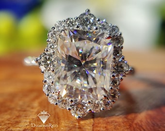 May include: A silver ring with a large, square-shaped diamond surrounded by a halo of smaller diamonds.