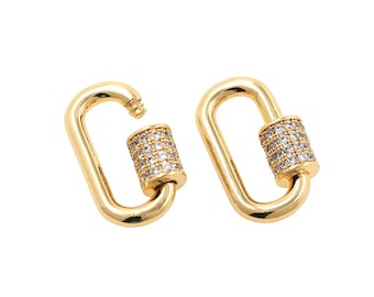 May include: Two gold-toned metal clasps with a clear crystal-encrusted barrel. The clasps are oval-shaped and have a spring-loaded mechanism.