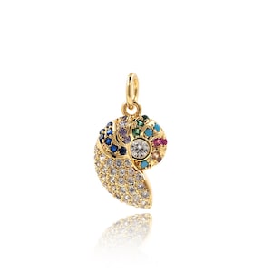 May include: A gold-tone pendant charm shaped like a nautilus shell with colorful gemstones and clear rhinestones.