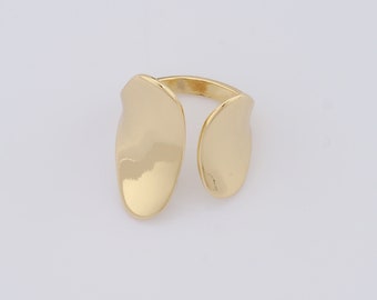May include: A gold-toned ring with a unique, abstract design. The ring is made of two oval-shaped pieces that are connected by a thin band.