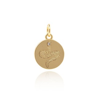 Puede incluir: Encanto de colgante de oro con un diseño de serpiente y un pequeño acento de diamante. El colgante es redondo y tiene un acabado liso y pulido.