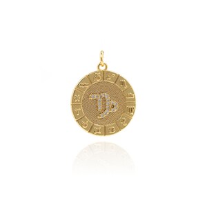 May include: Gold-toned zodiac pendant featuring a Capricorn symbol with clear rhinestones. The pendant is round and has all 12 zodiac signs around the edge.