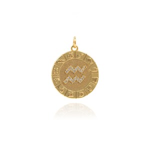 May include: Gold zodiac pendant featuring the Aquarius symbol with clear rhinestones. The pendant is round and has all 12 zodiac signs around the edge.