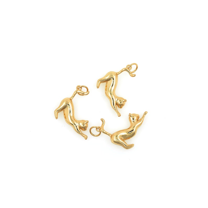 May include: Three gold-colored cat charms with a loop for attaching to a necklace or bracelet.
